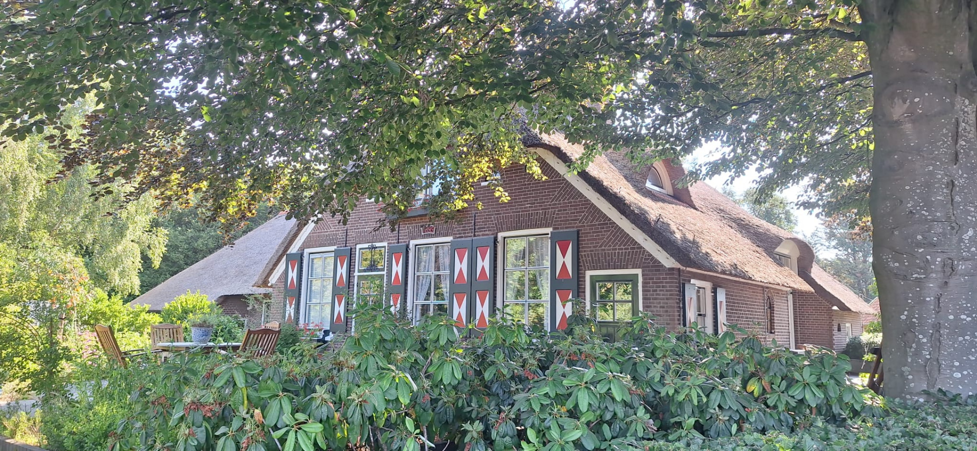 Veluws boerderijtje met rieten dak tussen groene bomen in de buitengebieden rondom Nijkerk
